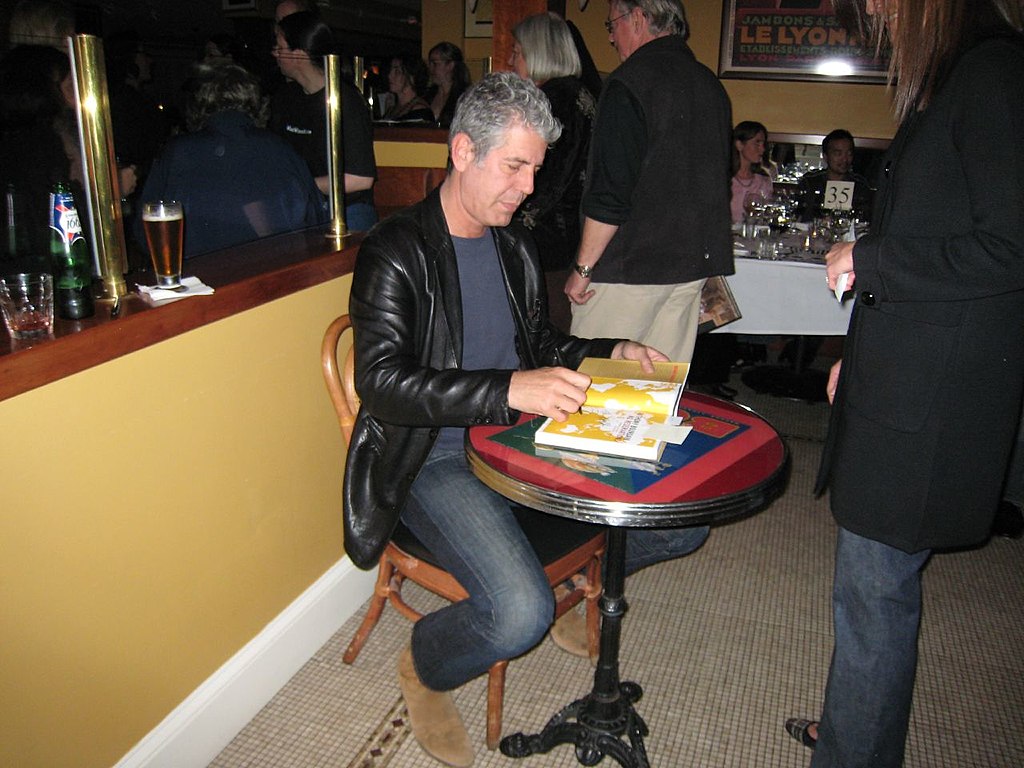 Anthony Bourdain signing a copy of No Reservations.